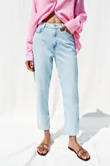 Pantalón de jean celeste claro, de corte mom fit, tiro alto y largo tobillero.
