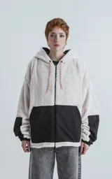 Campera reversible con cierre. Un lado de tela corderito color crudo y otro de tela tipo bomber color negro.