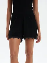 Short de pijama color lila con estampado de flores blancas y ribete de encaje en el ruedo.