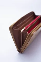 Billetera marrón con estampado de piel de serpiente, cierre perimetral, múltiples ranuras para tarjetas, documentos y billetes, y bolsillo interior con cierre para monedas.