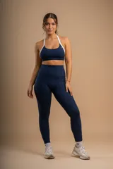 Conjunto deportivo azul marino compuesto por un top con breteles blancos y calzas largas de tiro alto con bolsillos laterales.