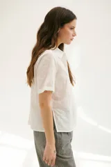 Camisa blanca de mangas cortas con estampado de hojas.