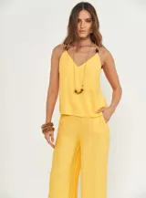 Musculosa amarilla con tirantes finos y detalle de apliques de madera en los tirantes.