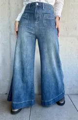 Pantalón de jean azul de corte pata de elefante, con bolsillos frontales tipo parche.