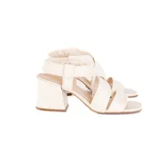 Sandalia de cuero color blanco hueso, con tiras cruzadas acolchadas, talón elástico fruncido, taco ancho de 6 cm y punta cuadrada.