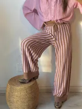 Pantalón de punto marrón con rayas verticales rosas, corte palazzo y cintura con cordón ajustable.