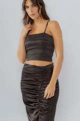 Top corto negro con tirantes finos y diseño a capas horizontales.