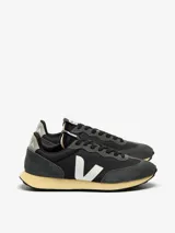 Championes Veja modelo Rio Branco, con capellada de malla técnica negra y superposiciones de gamuza gris. Logo lateral en forma de "V" color blanco.