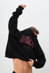 Buzo negro de corte holgado con estampa frontal de letras en color borgoña que dice "BROOKLYN" y "NEW YORK".