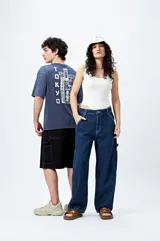 Pantalón de jean azul oscuro, corte amplio y estilo carpenter, con bolsillos utilitarios y presillas laterales.