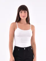 Musculosa sin costuras, color blanco, de tirantes finos y ajuste ceñido al cuerpo.