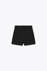 Shorts de tiro alto color negro, con trabillas en la cintura, bolsillos laterales y cierre frontal con cremallera y ganchos metálicos.