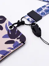 Llavero porta tarjeta con cinta estampada con diseño de hojas en tonos beige, azul y violeta.