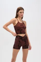 Conjunto deportivo gris con estampado abstracto negro, compuesto por un top ajustado de breteles finos y cuello redondo, y un short de tiro alto con cintura cruzada.