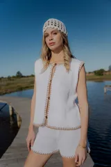 Conjunto tejido de algodón color celeste con terminaciones en marrón. Incluye un top sin mangas con botones y un short de tiro alto.