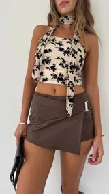 Short pollera de cuero sintético color marrón y negro, con hebilla metálica plateada.
