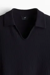 Remera negra de punto texturizado de mezcla de algodón con cuello y miniabertura en V. Corte estándar.