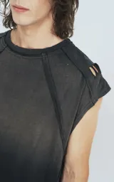 Remera negra sin mangas con efecto degradado y roturas en los hombros, de corte oversize.