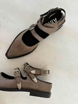 Ballerinas de cuero color marrón con punta fina y dos tiras con hebillas.