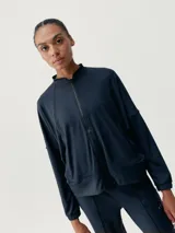 Campera negra de manga murciélago con cierre frontal y bolsillos laterales.