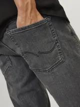 Jean gris de corte slim fit, tiro bajo, rodilla ajustada y pierna ceñida.