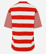 Remera de algodón con cuello redondo, cuerpo a rayas horizontales anchas verdes y blancas, y mangas cortas con rayas horizontales finas verdes y blancas. Presenta sisas desplazadas y costuras aparentes.