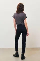 Pantalón jean negro de corte slim con detalles de tachas plateadas en los bolsillos delanteros y en el ruedo.