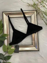 Bralette negro de lycra con corte triangular, breteles regulables y cierre trasero con gancho.