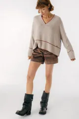 Sweater beige y azul con cuello en V y ribete bordeaux.