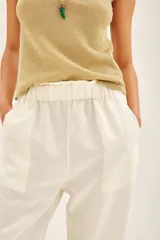 Pantalón recto negro de lino con bolsillos laterales y elástico interno en la cintura.