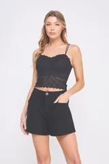 Top corto negro de encaje elastizado con breteles finos ajustables, escote recto con detalle de ondas y copas preformadas.