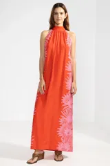 Vestido largo color rojo con estampado floral rosa, cuello halter y espalda descubierta.