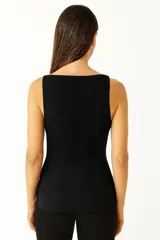 Musculosa naranja de punto canalé, con breteles finos y escote recto.