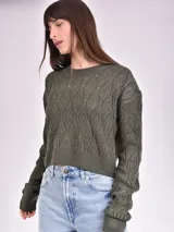 Sweater de punto calado color crudo, de corte holgado y mangas largas.