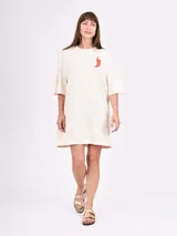 Remera de algodón color beige claro, corte oversize y manga corta, con un pequeño estampado de ají rojo en el pecho.