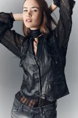 Chaleco negro de cuero ovino con corte entallado, botones al frente y tira de ajuste en la espalda. Diseño con flecos, tachas doradas y apliques en cuero con estampado snake.