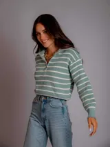 Sweater color beige a rayas horizontales blancas, con cuello polo y cierre metálico.