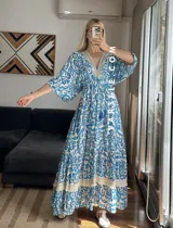 Vestido largo con estampado floral en tonos celeste y blanco, escote en V con detalle de bordado y mangas cortas amplias.
