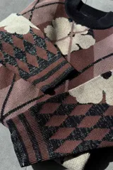 Sweater de punto con cuello redondo y estampado de rombos y flores en tonos violeta, marrón y rojo.