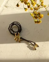 Collar con dije de bronce macizo con forma orgánica o de coral, suspendido de un hilo de seda natural color naranja.