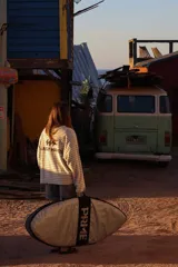 Buzo de manga larga reversible. Un lado es color arena con rayas horizontales marrones y el otro lado es azul marino liso.