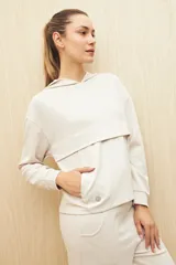 Canguro marrón con capucha, corte amplio y detalle de recorte frontal.