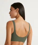 Sujetador top color verde militar, sin copa, sin aro, sin costuras, sin cierre y sin tirantes ajustables. Detalle ondulado en la parte delantera.