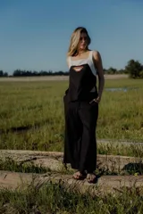 Conjunto de top y pantalón color beige. El top es de breteles anchos, con escote cuadrado y detalle de bordado en el frente. El pantalón es de corte recto y ancho, con bolsillos laterales y cintura con elástico y botones.