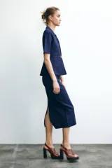 Falda midi azul marino de punto liso, de tiro alto con cintura elástica y abertura en la parte trasera.