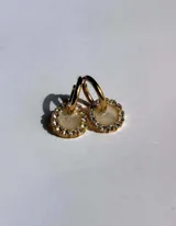 Par de aros dorados con dije circular de resina color terracota con glitter y borde de strass.