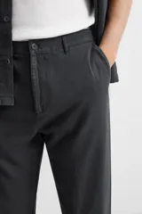 Pantalón negro de corte recto, confeccionado en tejido de mezcla de algodón y lino. Presenta cintura elástica, bolsillos laterales y traseros.