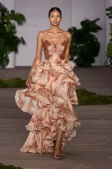 Vestido largo de fiesta color beige con estampado de hojas en tonos marrones, con corpiño bordado con cuentas y falda con volados.