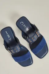 Sandalias de tacón color borgoña, con dos tiras de cuero, una de gamuza y otra con hebilla y ojalillos metálicos. Taco cuadrado forrado en cuero.
