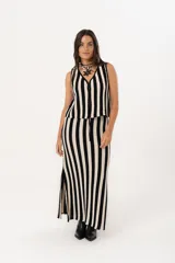 Pollera larga tejida a rayas verticales negras y beige, con pretina elástica y tajos laterales.